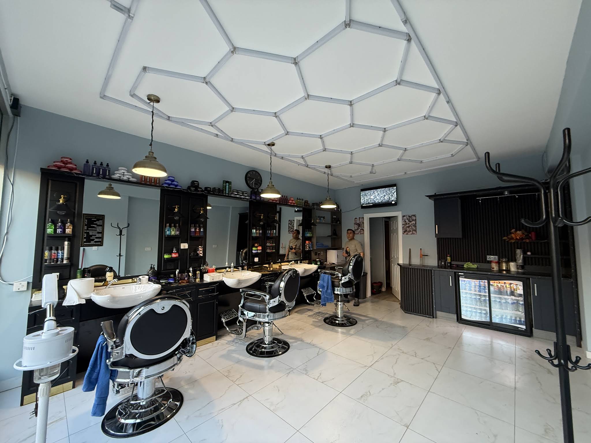 Interior of Royal Barbers Shirley with classic barber chairs and hexagon lighting